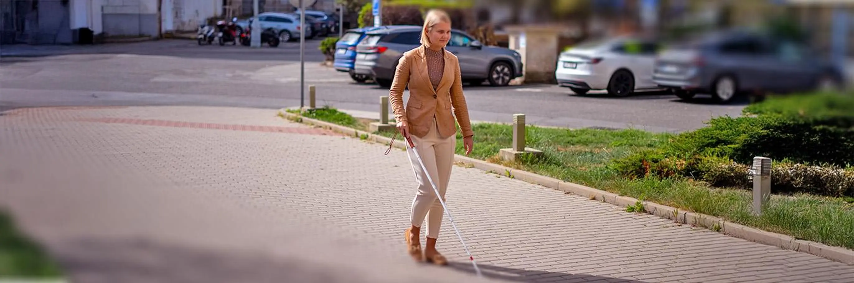 Kráčející nevidomá žena s bílou holí