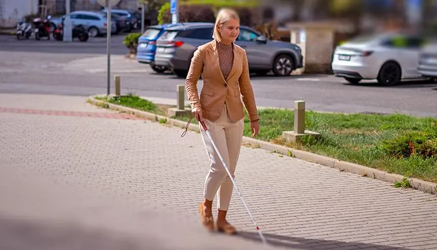 Kráčející nevidomá žena s bílou holí